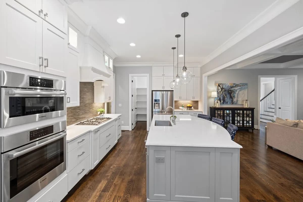 Stainless steel double wall ovens in a white kitchen